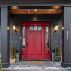 a red front door with two potted plants on either side and one planter next to it