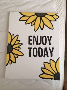 a close up of a bed with a white sheet and yellow sunflowers on it