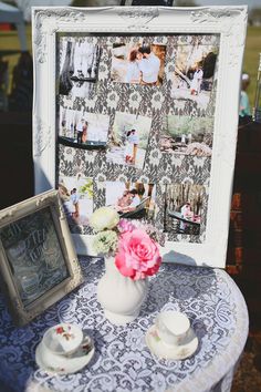 a table topped with a white vase filled with pink flowers next to a framed photo