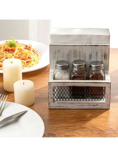 a wooden table topped with white plates and silverware