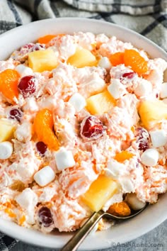 a bowl filled with fruit salad on top of a table