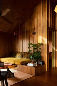 a living room with wood paneling and plants on the table in front of it