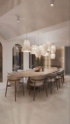 a dining room table and chairs with lights hanging from the ceiling