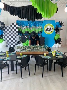 a table with black chairs and green decorations