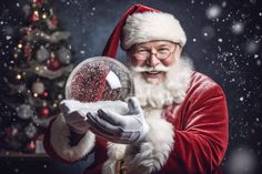 santa claus holding a snow globe in front of a christmas tree