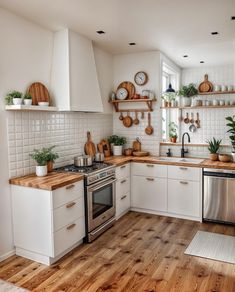 a kitchen with wooden floors and white cabinets, wood counter tops and open shelving above the stove