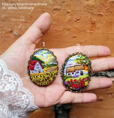 two handmade brooches in the palm of someone's hand