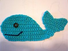 a crocheted blue whale with a black button