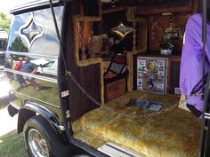 the back end of an old fashioned vehicle with items in it's storage compartment