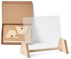 an open cardboard box with two pieces of wood in it and a white board on the bottom