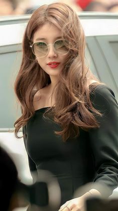 a woman with long brown hair wearing sunglasses