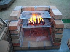 an outdoor fire pit with flames burning in it