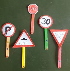 three different colored road signs and one stop sign are on top of each other in front of a chalkboard