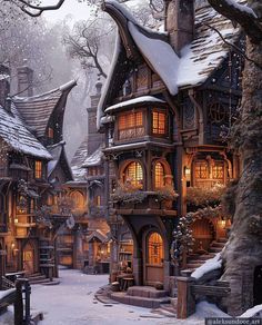 a snow covered village with lots of windows and lights in the night time, surrounded by trees