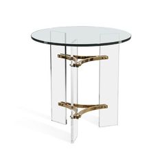 a round glass table with metal legs and a gold plated frame around the base