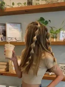 a woman standing in front of shelves holding a cup