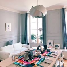 a living room filled with furniture and a large window next to a white couch in front of a table