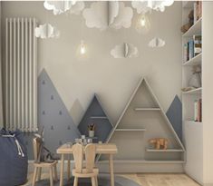 a child's room with mountains and clouds painted on the wall, along with a table and chairs