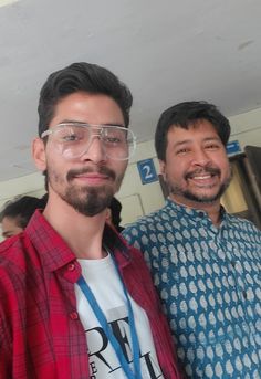 two men standing next to each other wearing glasses