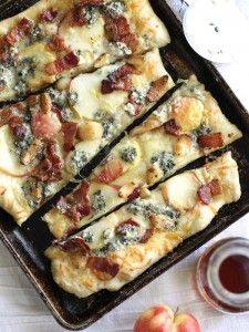 several slices of pizza sitting on top of a pan next to an apple and cup of tea