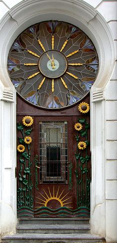 an ornate door with sunflowers painted on the front and side panels above it