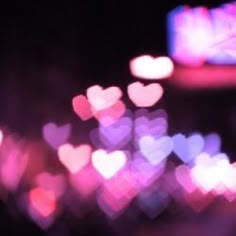 blurry image of many hearts in the dark night sky with pink and purple lights