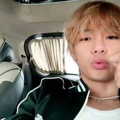 a young man making a silly face while sitting in the back seat of a car