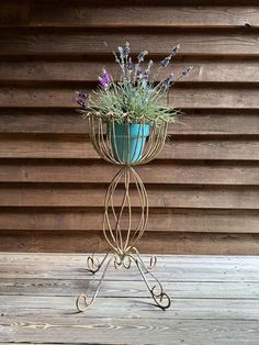 a potted plant sitting on top of a metal stand next to a wooden wall