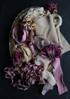 a basket filled with lots of different types of cloth and flowers on top of a table