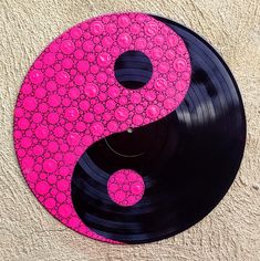 a pink and black yin - yang symbol on a white background with circles around it