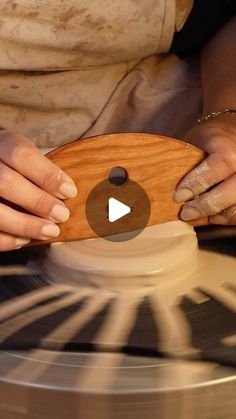 a person using a spinning wheel to spin a wooden object on it's surface