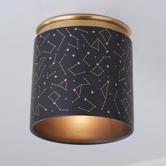 a black and gold ceiling light with stars on it's lampshade hanging from the ceiling