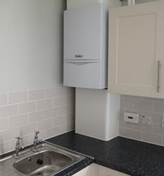 a kitchen with white cabinets and black counter tops