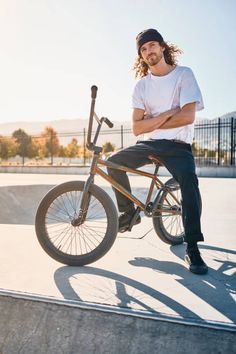 a man sitting on top of a bike at a skate park