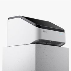 an air purifier sitting on top of a cement block in front of a white wall