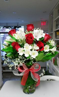 a vase filled with white and red flowers