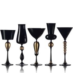 black and gold wine goblets lined up in a row on a white background