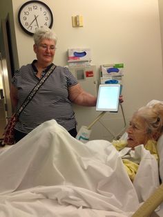 an elderly woman in a hospital bed with a nurse