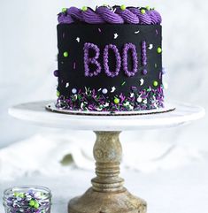 a decorated birthday cake sitting on top of a white plate with sprinkles