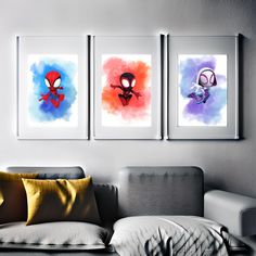 three spider - man paintings hang on the wall above a couch in a living room