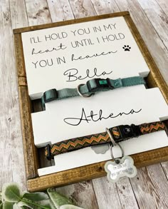 two personalized dog collars in a wooden box with a tag attached to it