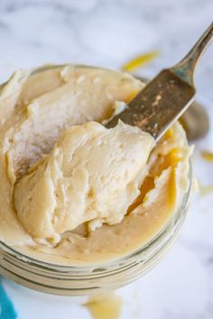 a spoon in a jar filled with peanut butter