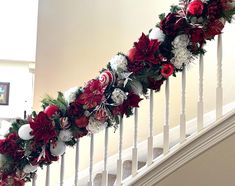 a christmas garland on the banisters is decorated with red, white and green ornaments