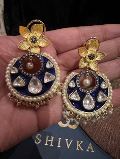 These gorgeous earrings will add a perfect charm to your occasion wear. You will definitely fall in love with this beauty and it will make you stand out among the crowd. Length: 6.5 cms Width: 3.5 cms One of a kind. The uncut Kundan stones embellished on a blue meenakari (enameled) base with pearl drop clusters make it a statement pair. The earrings are the same as shown in the pictures. We have only one piece in this design and color, hence you get what you see in the pictures. Fusion Style Festive Chandbalis For Pierced Ears, Chandbali Fusion Hoop Earrings For Celebration, Fusion Style Chandbali Hoop Earrings For Celebration, Tilla Chandbali Earrings For Celebration, Fusion Hoop Earrings With Latkans For Celebration, Fusion Style Hoop Earrings For Festivals And Celebrations, Fusion Style Hoop Earrings For Celebrations And Festivals, Bollywood Tilla Round Earrings, Hand Set Round Hoop Earrings For Wedding