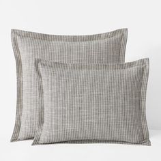 two pillows sitting next to each other on a bed