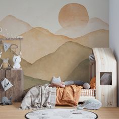 a child's bedroom with mountains painted on the wall and toys in the foreground