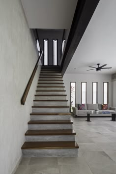 the stairs lead up to the second floor in this modern house with white walls and wood trimmings