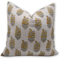 a gray and yellow floral pillow with orange flowers on the front, sitting on a white background