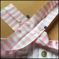 a pink and white striped shirt with buttons on the lapel, next to a buttonhole