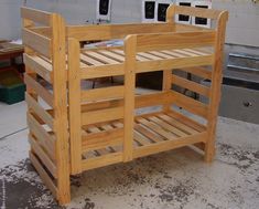 a wooden bunk bed sitting on top of a cement floor